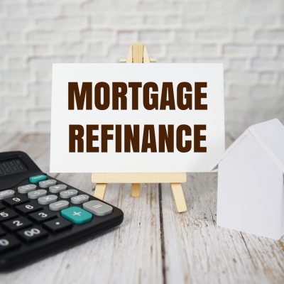 Mortgage refinance text message with calculator and house model on wooden background