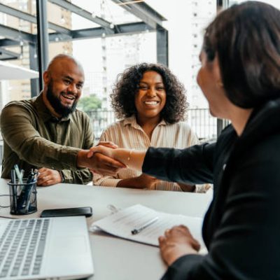 Couple closing real estate contract with real estate agent